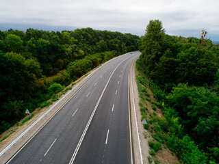 Aerial view asphalt road and green forest, Forest road going through forest with car adventure view from above, Ecosystem and ecology healthy environment concepts and background.