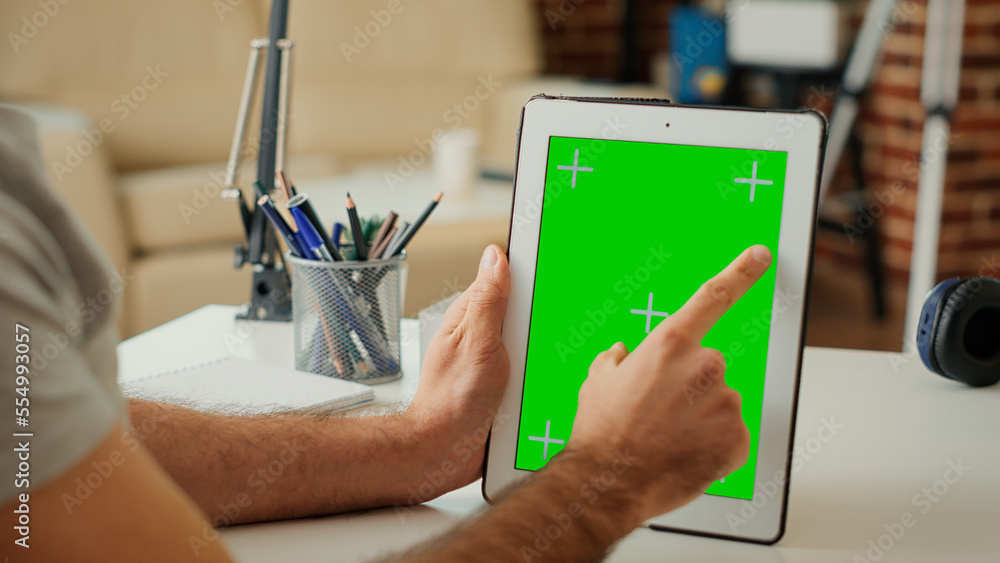 Poster office worker vertically holding digital device with isolated greenscreen, looking at chroma key dis