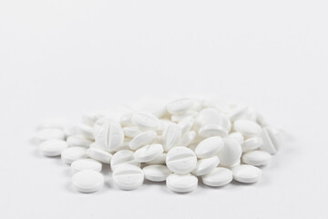 Fototapeta na wymiar many white round medical tablets for humans and animals, medicinal antibiotics pills medicine closeup