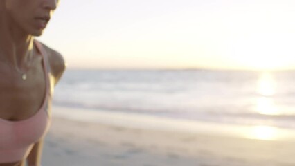 Woman, smart watch and running on sunset beach for healthcare wellness, cardiology exercise or body goals training. Runner, sports and personal trainer with time technology in sunrise nature fitness - Powered by Adobe