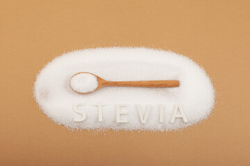 Pile of Stevioside powder and wooden spoon, top view. Food additive E960, Natural sweetener,...