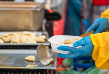 On a frosty winter day in central Krakow, a young charity volunteer fills a plate of free hot food for those in need. The tradition of selfless help to those in need before Christmas in Poland