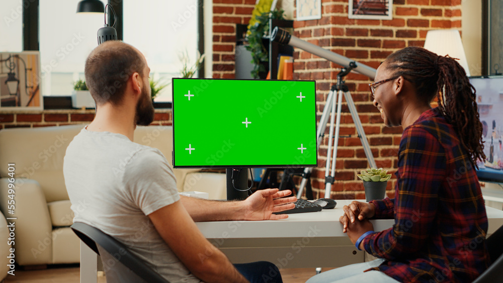 Poster diverse team of colleagues looking at computer with greenscreen, analyzing chroma key display on mon