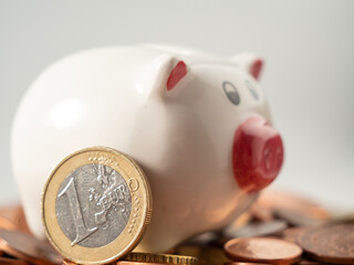 The piggy bank stands on metal coins. A bunch of euro cents and a piggy bank.