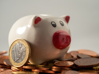 The piggy bank stands on metal coins. A bunch of euro cents and a piggy bank.