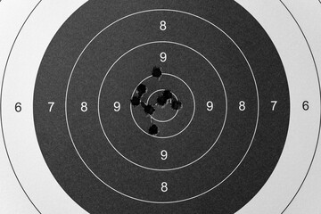 Classic shooting range target with bullet holes, close-up photo.