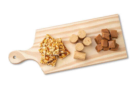 Typical brazilian candies over wooden board. Doce de leite or dulce de leche, pe de moleque and pacoca
