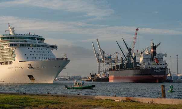 Port Canaveral, Florida, USA. 2022.  Cruise ship and sherriff boat in attendance underway passing a bulk carrier ship to depart into the Ocean