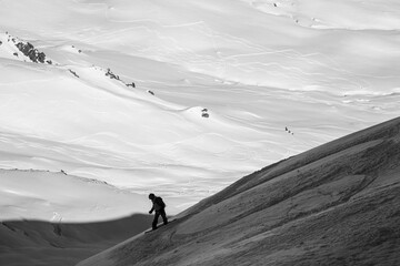 black and white photo of freerider snowboarder riding down snow-covered slope