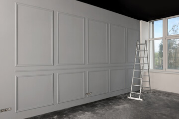 Metal ladder in empty room prepared for renovation