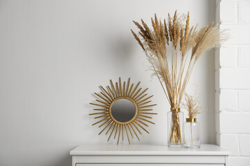 Stylish decorative vases on commode in room