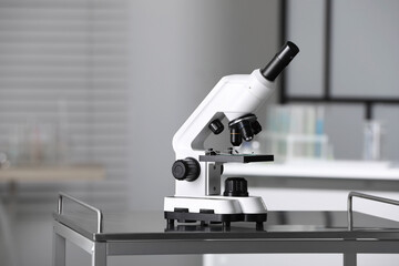 Modern medical microscope on metal table in laboratory, space for text