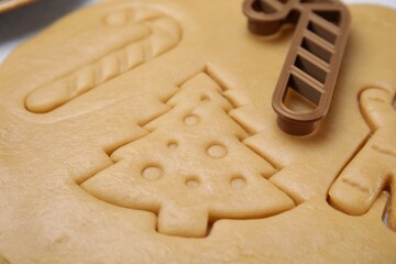 Christmas treat. Cookie cutter and dough on table, closeup