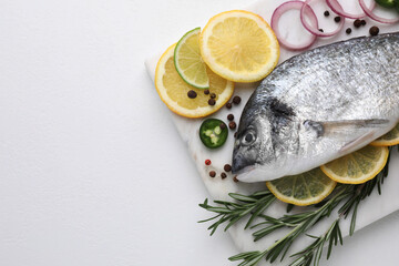 Fresh dorado fish and spices on white table, top view. Space for text