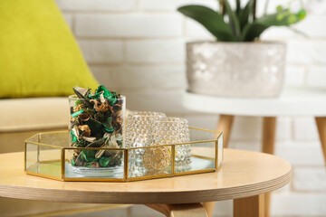 Glass jar with aromatic potpourri of dried flowers and different decor element on wooden table...