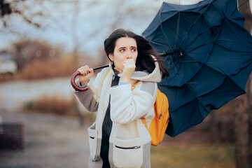 Woman Holding Her Umbrella Walking into a Windstorm. Unhappy person struggling in a storm fighting...