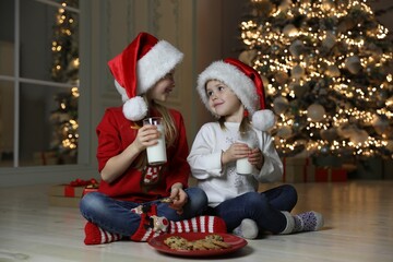 Fototapeta na wymiar Cute little children with milk and cookies at home. Christmas time