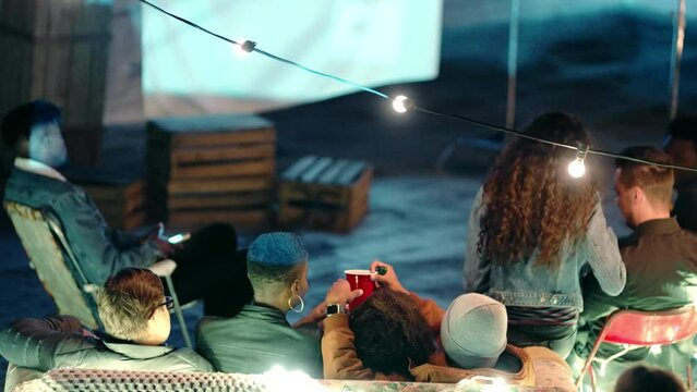 Night, movie or couple in an outdoor cinema watching a film on a retro or vintage big screen on holiday together. Projector, love or black woman enjoying a fun romantic play with partner at an event