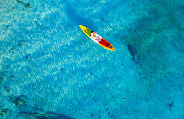 aerial view woman kayaking on the island of andaman View of the top view of the blue sea, see the rocks under the water. She does water sports activities.
