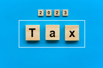 Wood blocks with tax word. Pay tax in 2023 years. The new year 2023 tax concept. Income tax return.