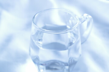 透明なグラスに入った水　白背景　余白スペース　シンプル　透き通った水　綺麗