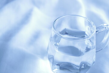 透明なグラスに入った水　白背景　余白スペース　シンプル　透き通った水　綺麗
