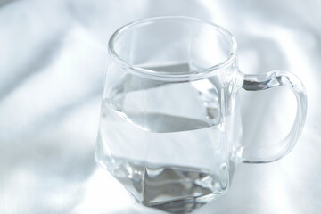透明なグラスに入った水　白背景　余白スペース　シンプル　透き通った水　綺麗