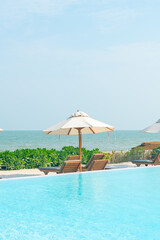 umbrella with bed pool around swimming pool with ocean sea background