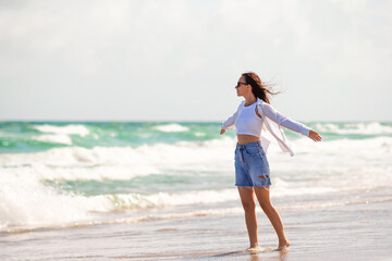 Young happy woman on the beach enjoy wind 