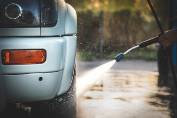 Close-up of a jet of water spraying around a high-pressure washing machine at a self-service car...