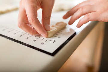 Close-up on a kitchen silicone baking mat with markings as a helper in the kitchen and the hands of a cook, copy space.
