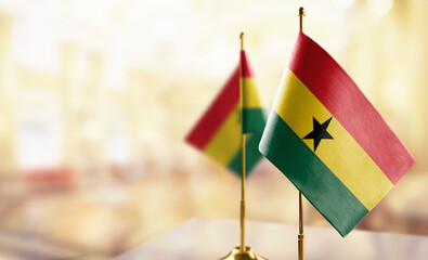 Small flags of the Ghana on an abstract blurry background