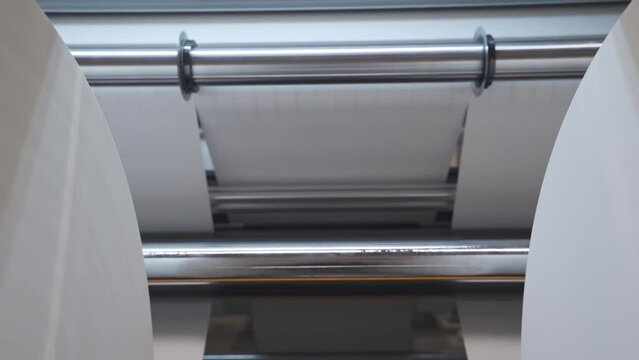 Huge Rolls Of Paper On Rolling Slitter For Custom Cutting In A Printing Factory. dolly-in shot