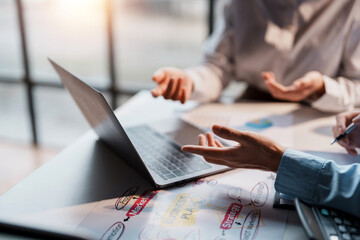 Businesspeople hand pointing at laptop computer to view business figures, graphs, charts, analyzing corporate finance marketing concepts Plan a marketing strategy on a laptop.