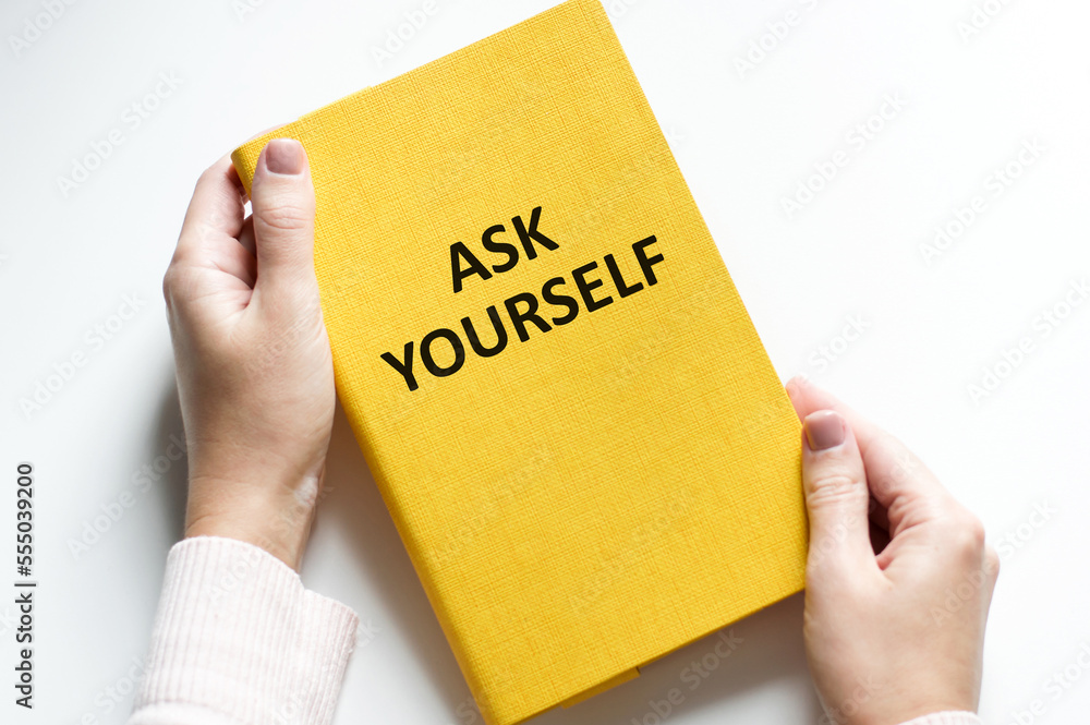 Poster a man writes on a piece of paper the text ask yourself. flat lay. view from above.