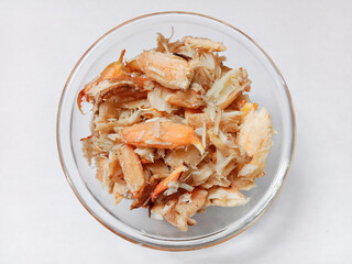 Top view of pile of fresh steamed crab meat in a bowl isolated on white background. Steamed crab meat ready to eat. Crab meat.