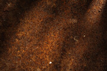 Rusty metal plate- corrosion on a dark red background. Abstract rust texture
