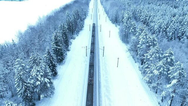 Shipping containers transportation on freight train by railway. Cargo Containers On Railroad in winter snow. Intermodal sea Container On Train Car in winter season. Rail Freight Shipping Logistics.