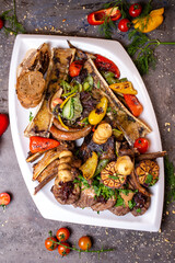 A set of different beef meat dishes on a white plate