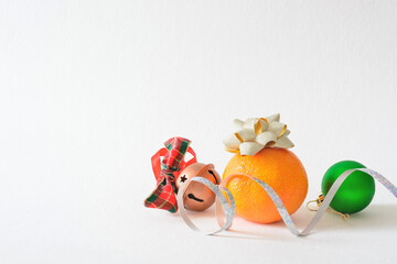 Light background with copy space Christmas decorations and tangerine