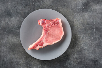 Fresh  Raw pork loin with bone over grey background. Pork chop.