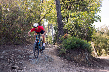young cyclist descending on a technical trail on his mountain bike, concept of freedom and sport in nature