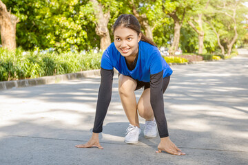 Asian woman in starting position ready for running