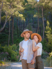 concept of embracing fresh air and engaging in outdoor activities. Loving young couple hugging and smiling together on nature background. Mountains Forest walk in Turkey