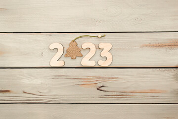 Happy New Year 2023. Symbol from number 2023 on wooden background