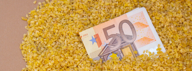 Euro bill paper money currency banknote in buckwheat porridge. The crisis in the market of grain...