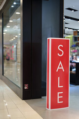 Sale text on a display board stand inside a popular clothing store during year end season sale