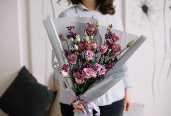 Very nice young woman holding big and beautiful mono bouquet of fresh pink eustoma flowers, cropped photo, bouquet close up - 555058672