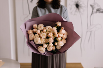 Very nice young woman holding big and beautiful mono bouquet of fresh tender pink bombastic roses,...