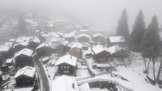 Snowy and snow-covered houses in the Swiss Alps. The village of Blatten near Belalp in fog and snow